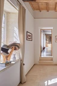 Bright corridor under beams, opening onto a run of rooms