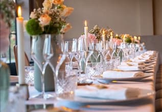 Place setting on a wooden table, with a floral arrangement